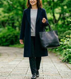 黒のトートバッグを持ち歩く女性のイメージ