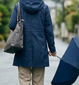 雨の日にトートバッグを持って歩く60代女性の後ろ姿