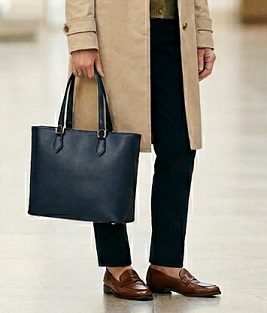 ネイビーのトートバッグを持つ女性