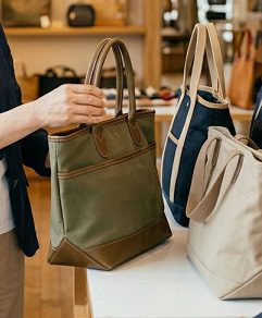 鞄を手に取って選ぶ、60代の女性