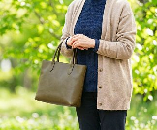 カーディガン姿でトートバッグを持つ女性