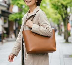 茶色のトートバッグを持つ女性