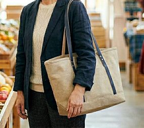 買い物をする、ベージュのトートバッグを肩にかけた女性
