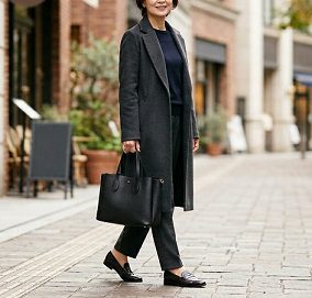 街中で、黒いトートバッグを持ち歩く女性のイメージ