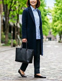 黒のトートバッグを持ち、街中を歩く女性のイメージ