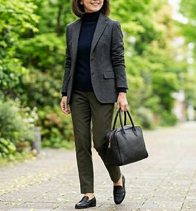 トートバッグを持って歩く、グレーの上着を着た女性
