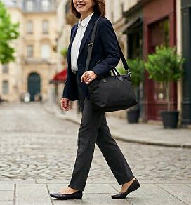 街中で、2wayの黒いトートバッグを持ち歩く女性のイメージ
