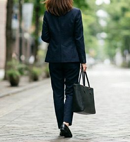黒色のトートバッグを持ち歩く女性のイメージ