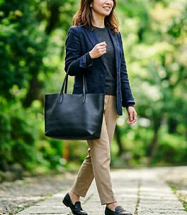 黒のトートバッグを持ち歩く女性のイメージ